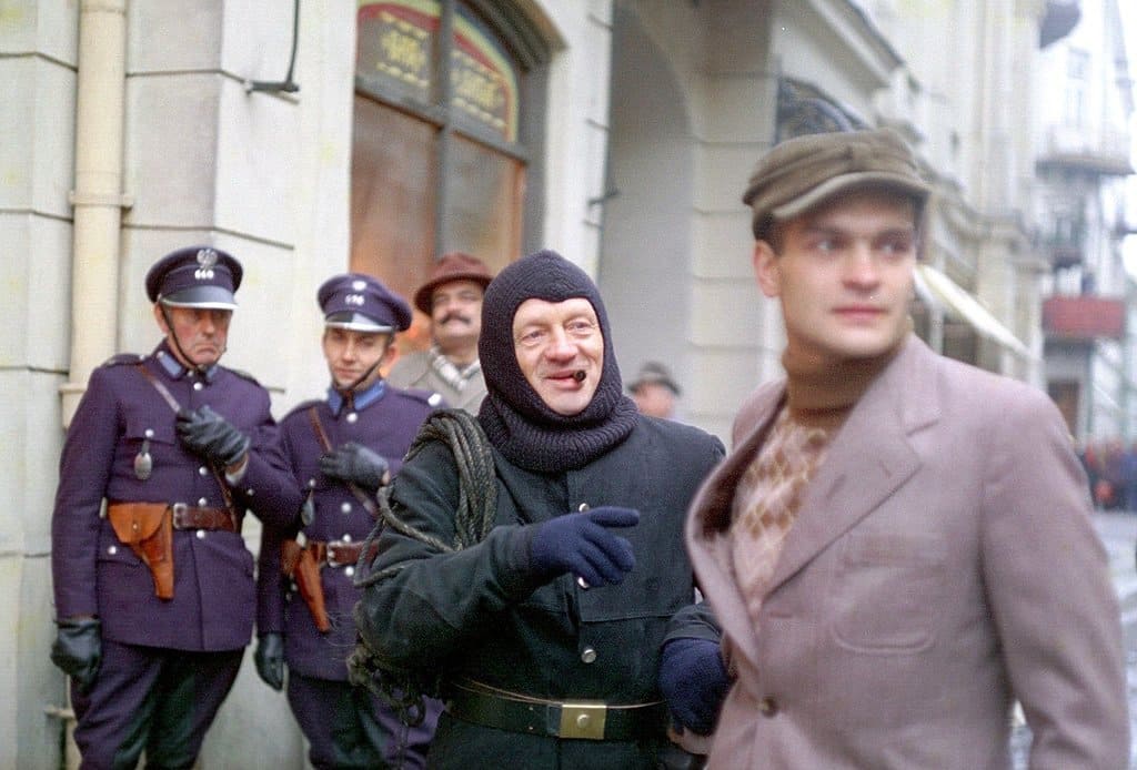 Два полицейских наблюдают за пьяными мужчинами, стоящими рядом.